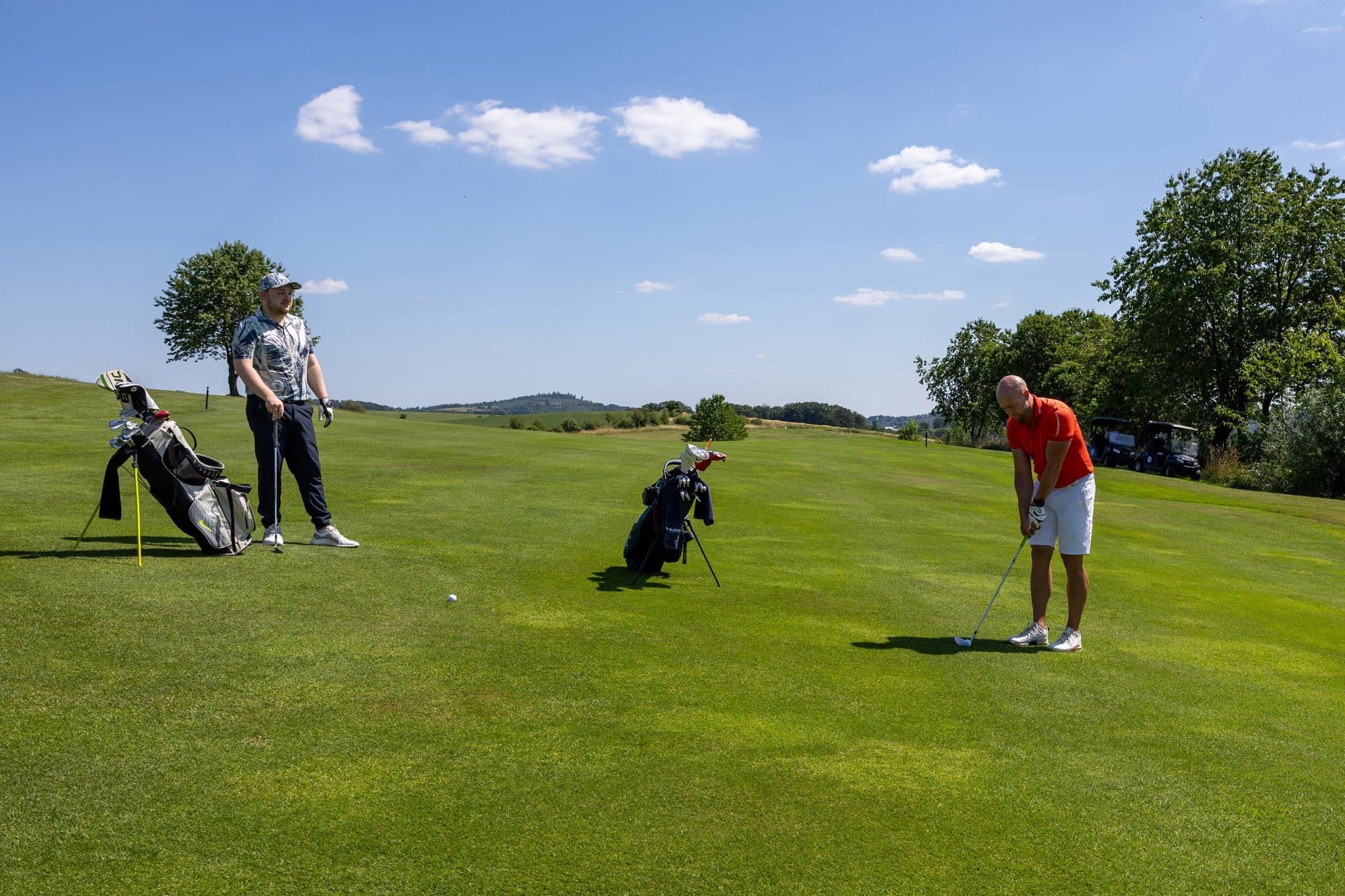 Zwei Spieler mit ihren Bags auf einem weiten Fairway