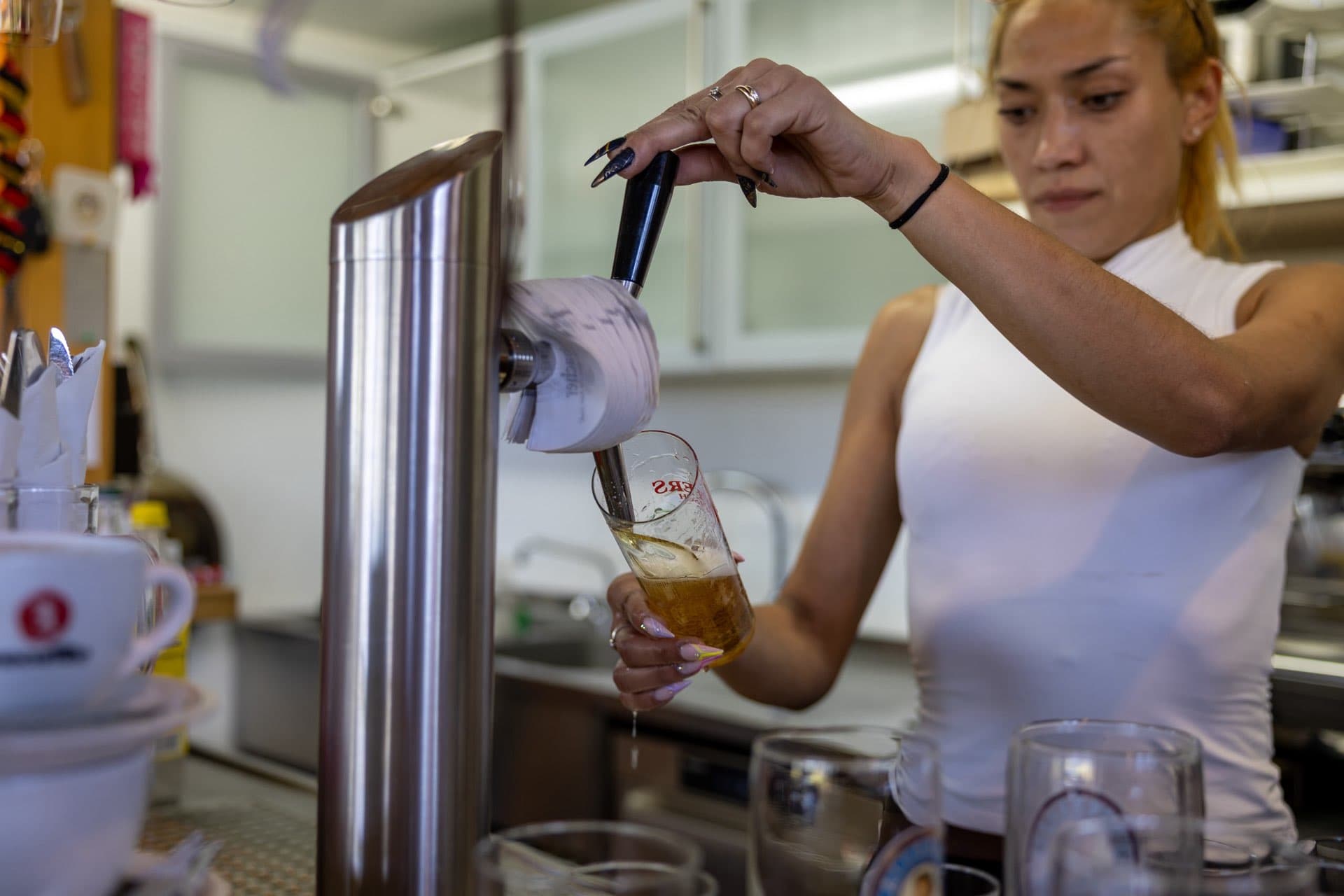 Frisch gezapftes Bier läuft in ein hohes Glas