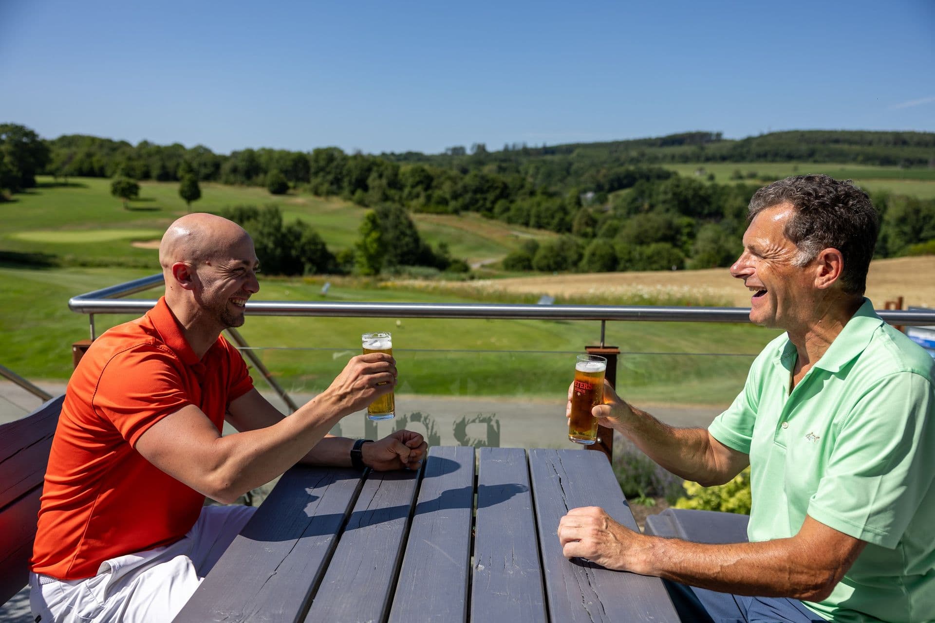 Zwei Mitglieder stoßen auf der Terrasse an
