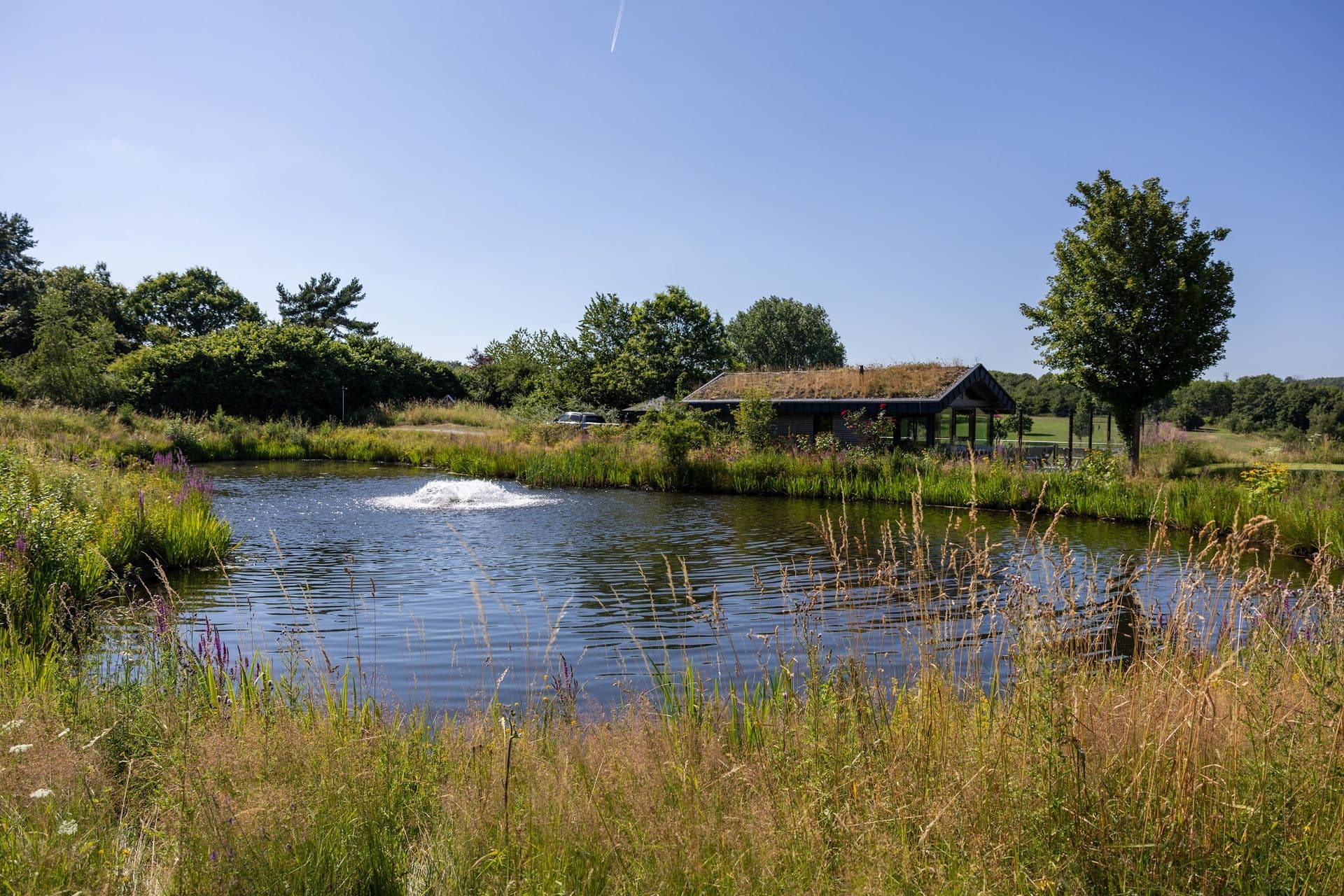 Das Halfway House des Golf Club Oberberg am Teich mit Fontäne