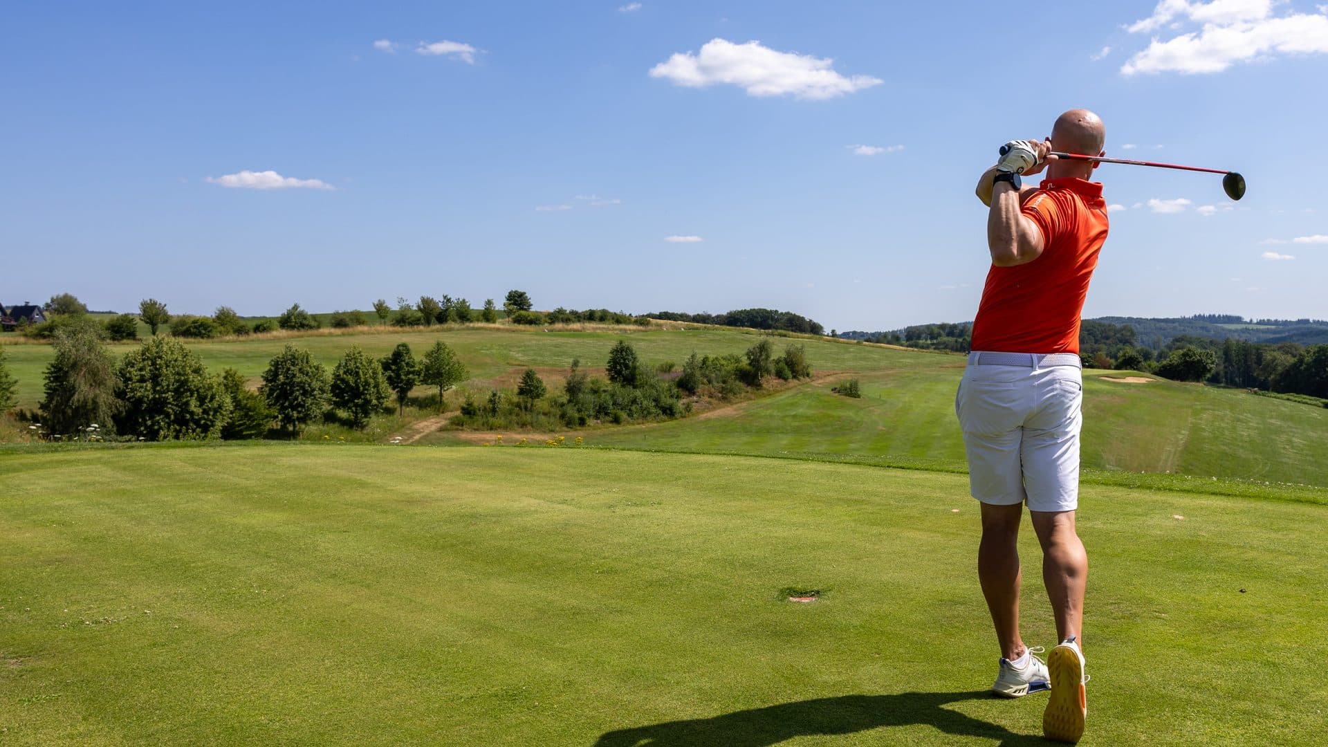 Golfer beim Abschlag auf dem Bohle Championship Course mit weitem Blick über das Oberbergische