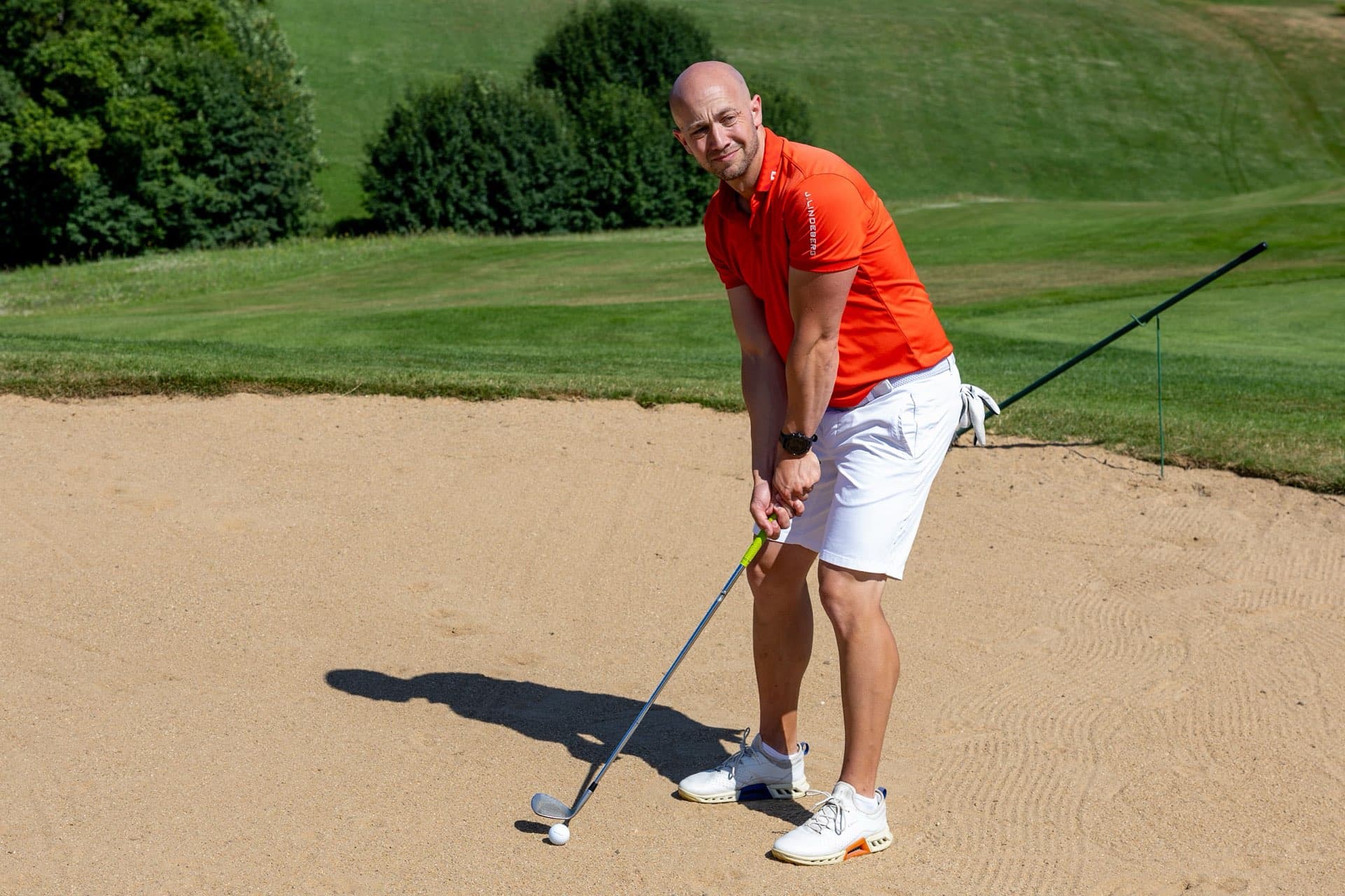 Spieler steht mit dem Wedge im Bunker am Ball