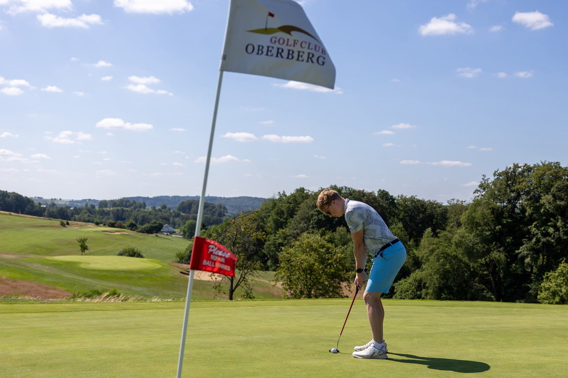 Spieler puttet auf dem Grün neben der Fahne des Golf Club Oberberg
